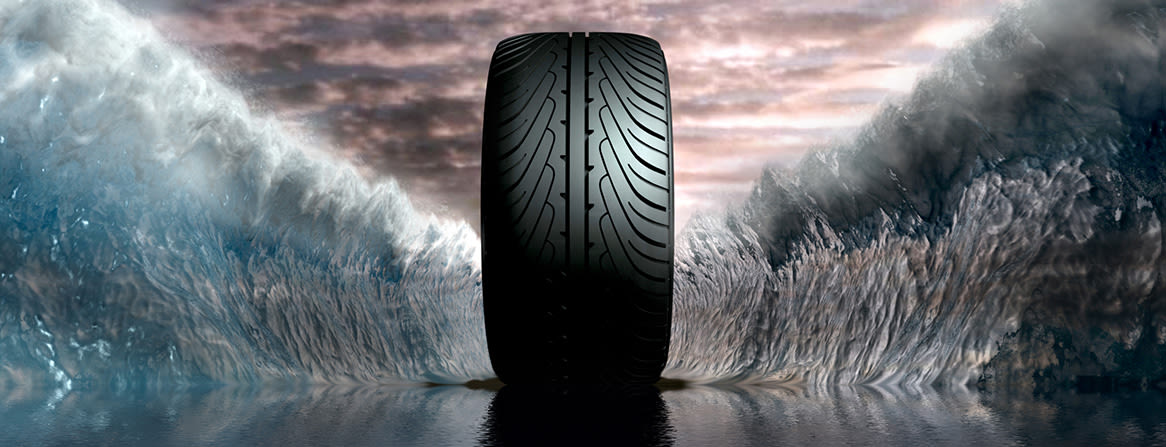 Dekk med kraftig mønsterbane skjærer gjennom vann – symbol på godt våtgrep og trygg kjøring i regnvær.