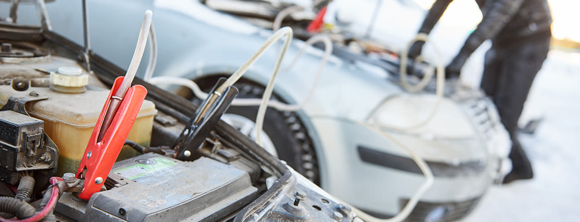 Startkabler koblet mellom to biler i vintervær.