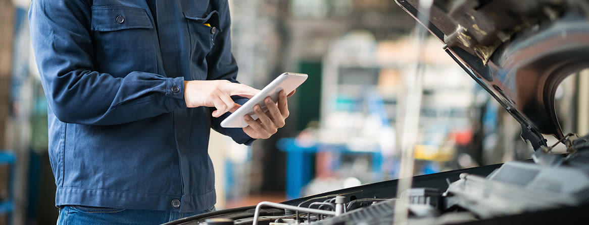 Mekaniker bruker nettbrett ved åpen panser.