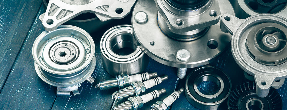 Hjullagre, tennplugger og andre bildeler i nærbilde.